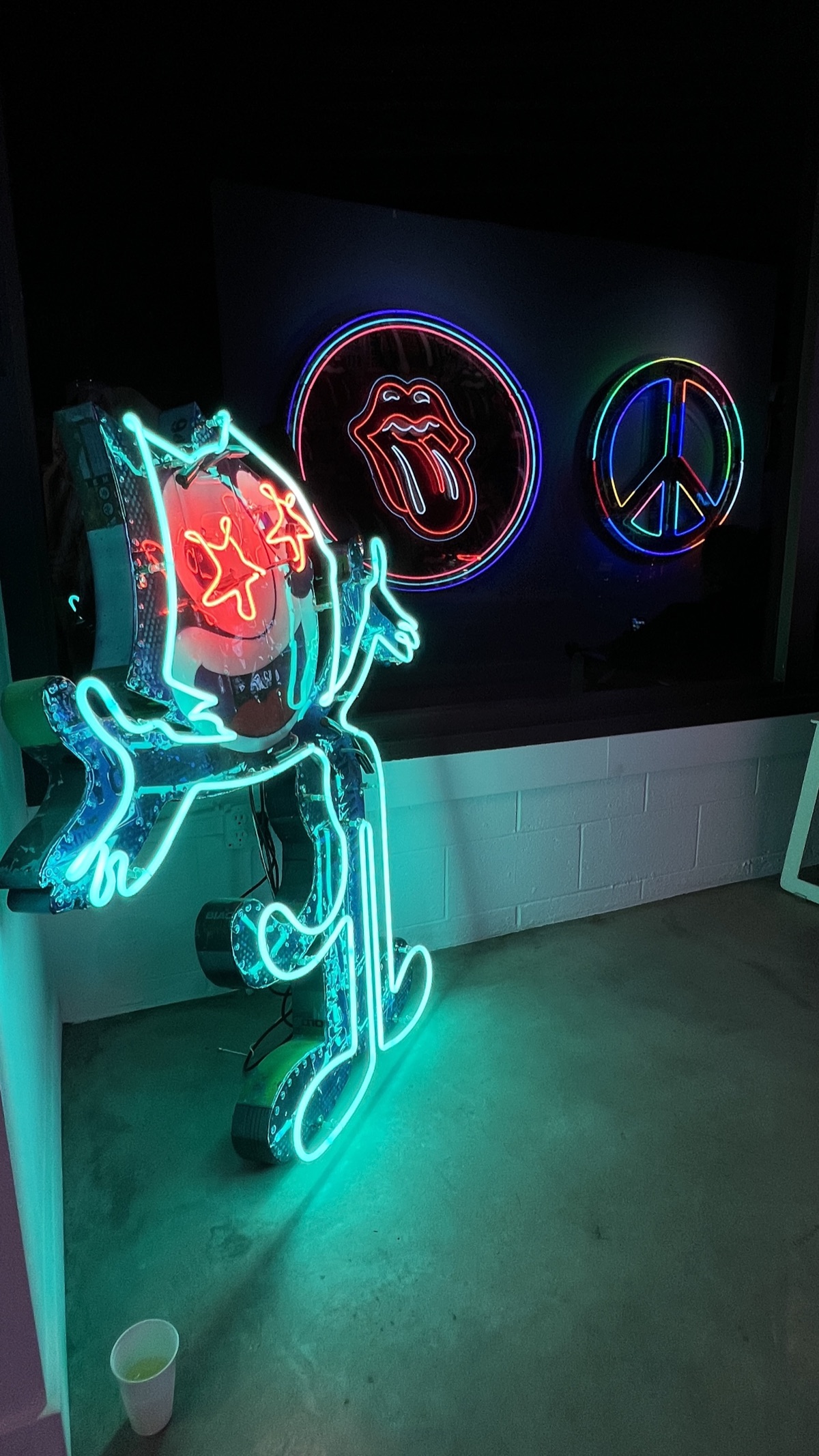 Neon figure artwork glowing in the gallery