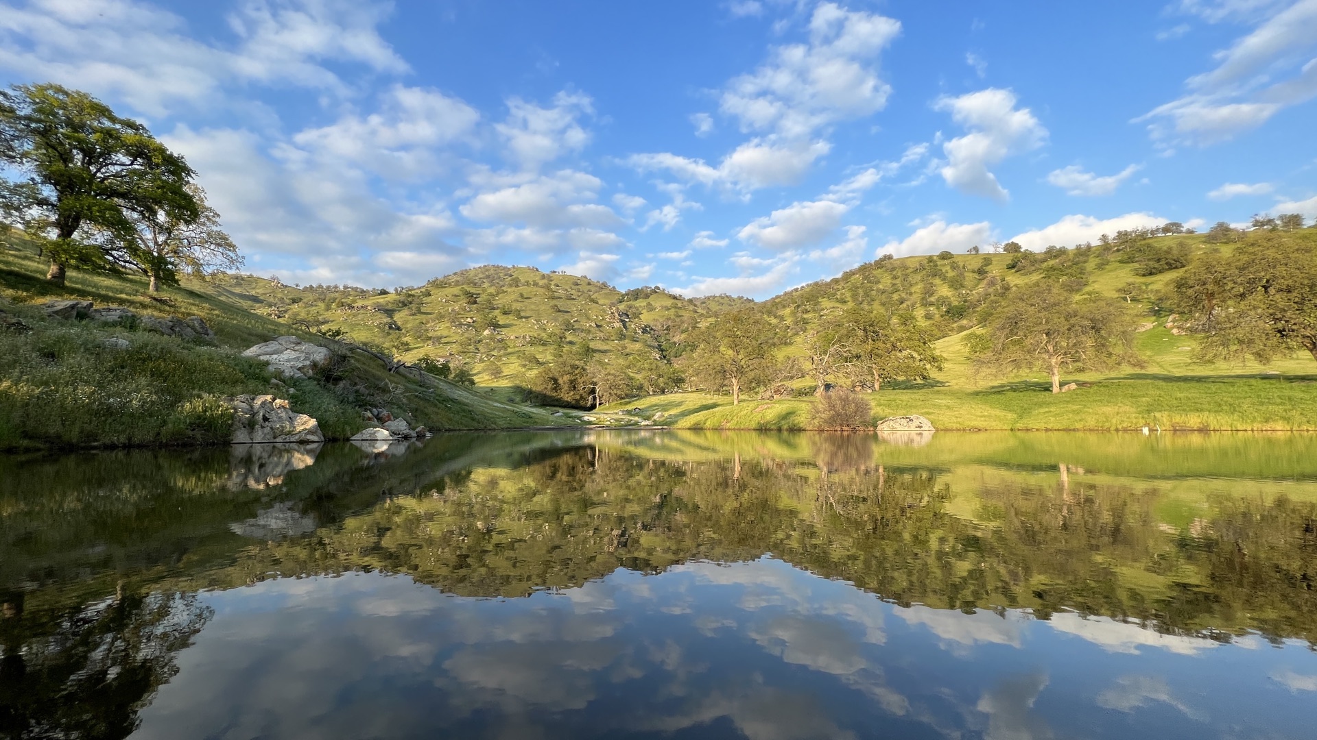 Golden-hour view across the pond and oak hills of Strader Life Ranch in Springville, California